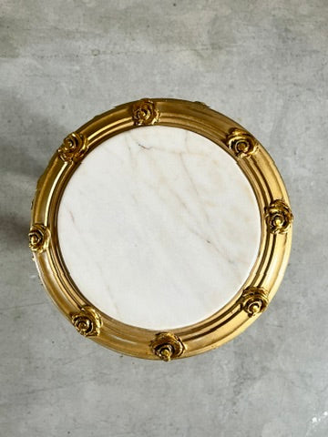 Small gold end table with beige marble top and hand-carved gold gilded accents, stylish furniture piece.