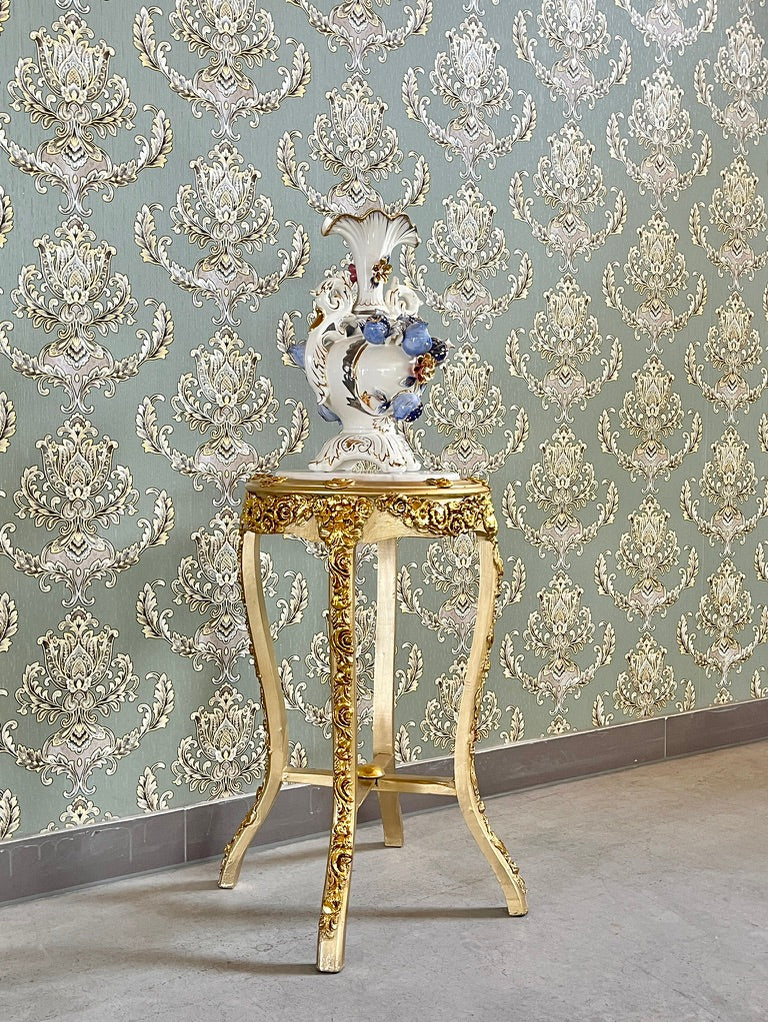 Small gold end table with beige marble top and hand-carved gold gilded details, showcasing elegant furniture design.